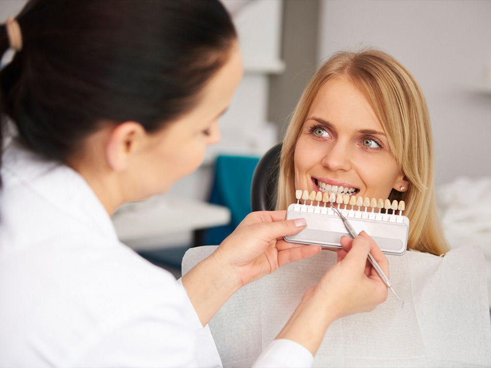 Woman having her teeth shade matched for dental crowns